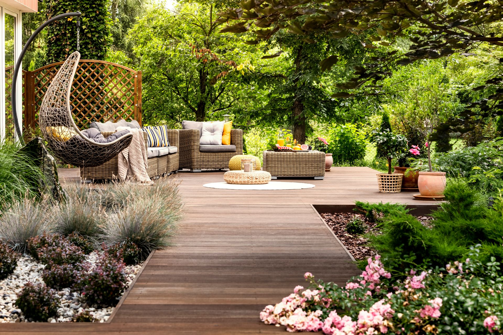 Hölzerne Terrasse im grünen Garten