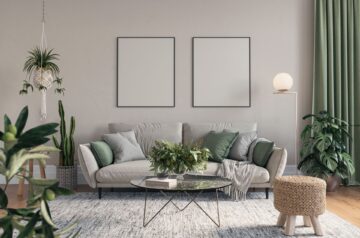 Ein modernes Wohnzimmer mit einer beigen Couch, grünen Akzenten und hängenden Pflanzen, dekoriert mit einem gemütlichen Alpaka Plaid.