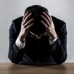 Unternehmer mit Burnout-Anzeichen am Tisch | Lohnbüro