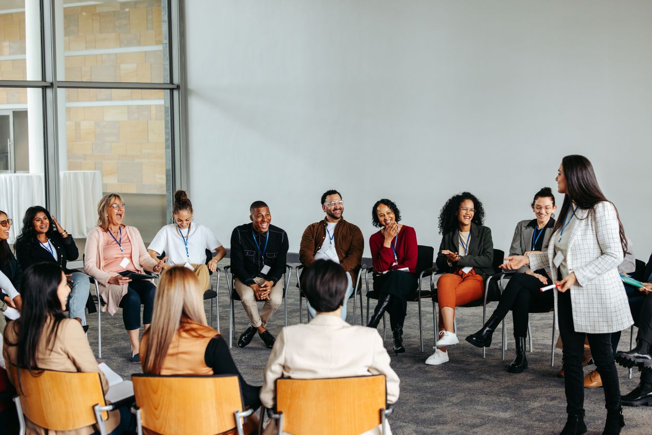 Gruppe reflektiert im Stuhlkreis uebungen aus einem Verhandlungstraining im Rahmen eines Coaching-Seminars