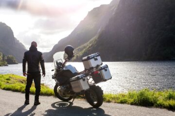 Motorradfahrer mit Satteltaschen an einem Fluss
