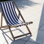 Gestreifter Liegestuhl auf heller Terrasse im Sonnenlicht – Symbolbild fuer Garteninspiration