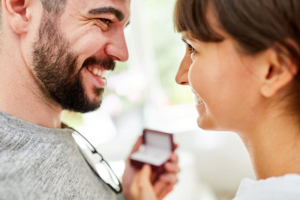 Laechelndes Paar beim Verschenken eines Schmuckstuecks – gefuehlvoller Moment mit thomas sabo