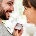 Laechelndes Paar beim Verschenken eines Schmuckstuecks – gefuehlvoller Moment mit thomas sabo