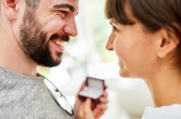 Laechelndes Paar beim Verschenken eines Schmuckstuecks – gefuehlvoller Moment mit thomas sabo